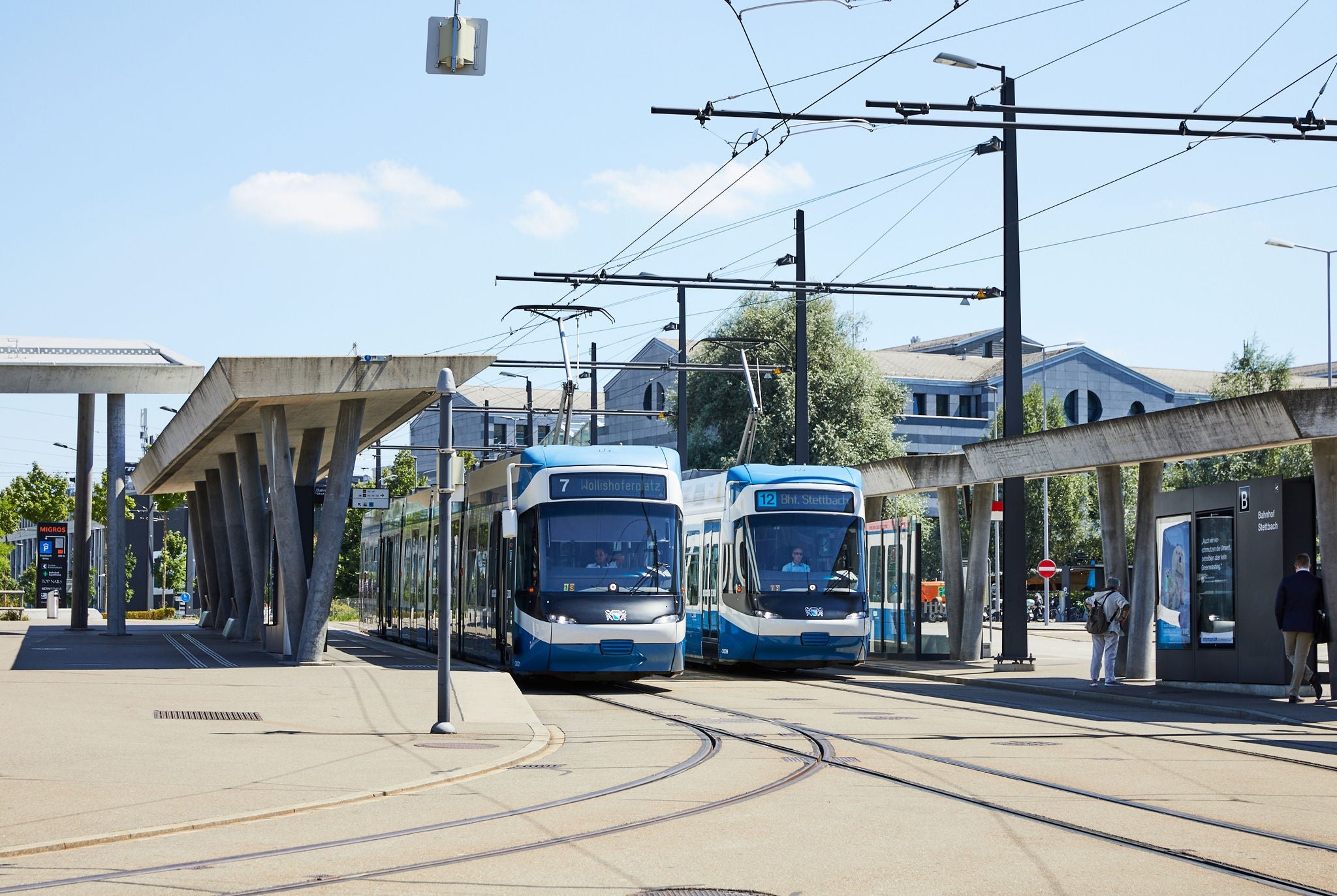 Tram, dass bei schönem Wetter unter Viaduktbrücke durchfährt.
