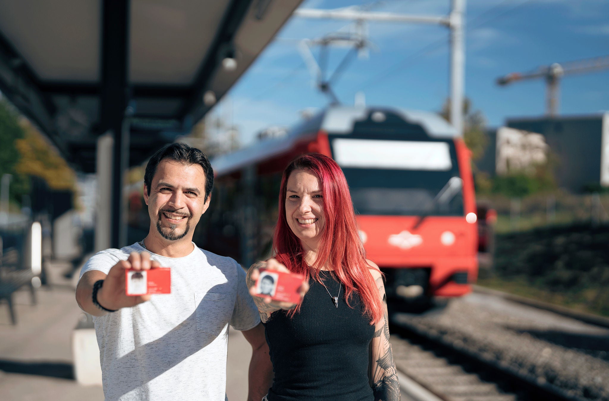 Paar zeigt SwissPass an SZU-Haltestelle