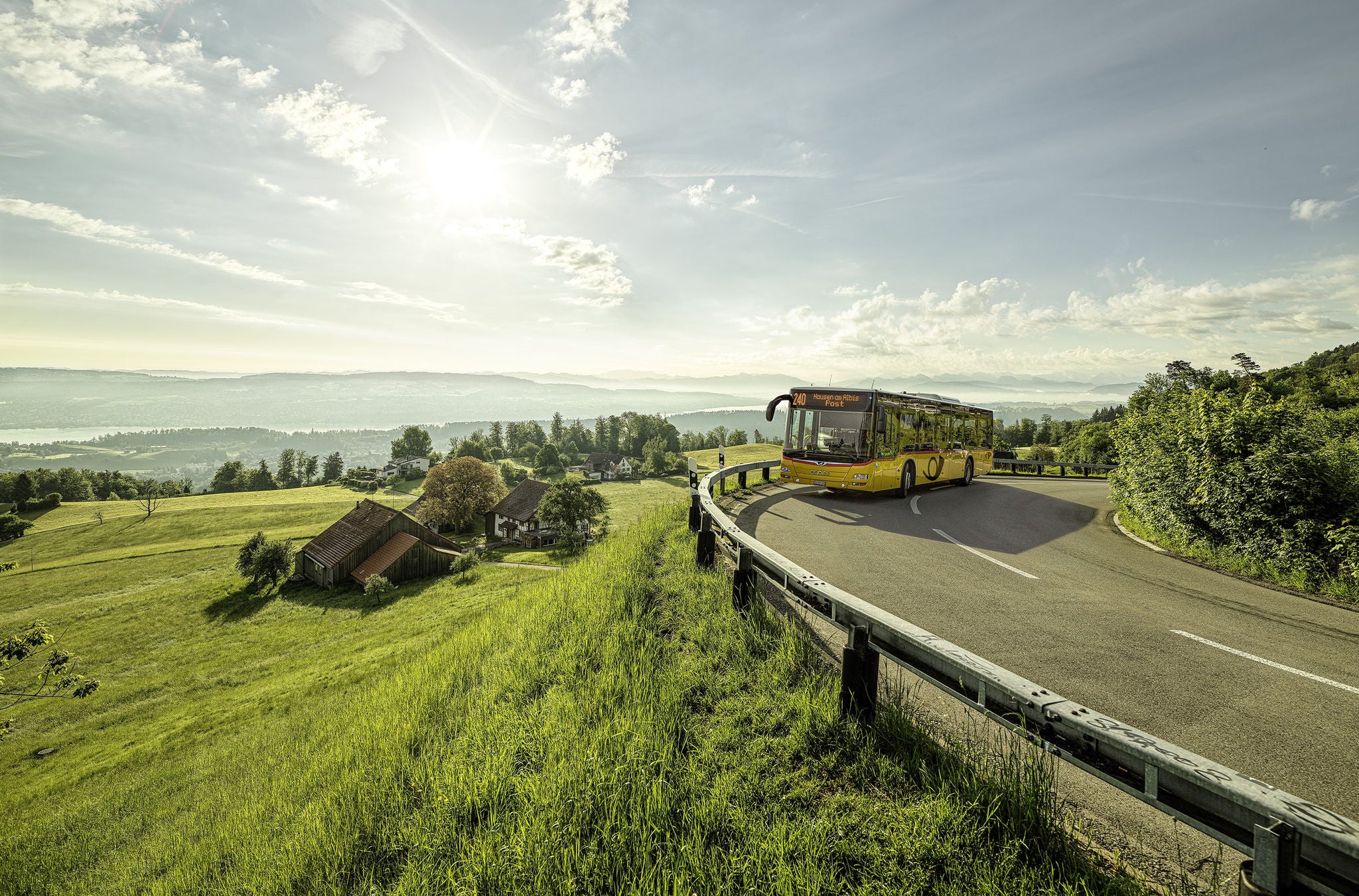 Ein Postauto fährt über eine Landstrasse.