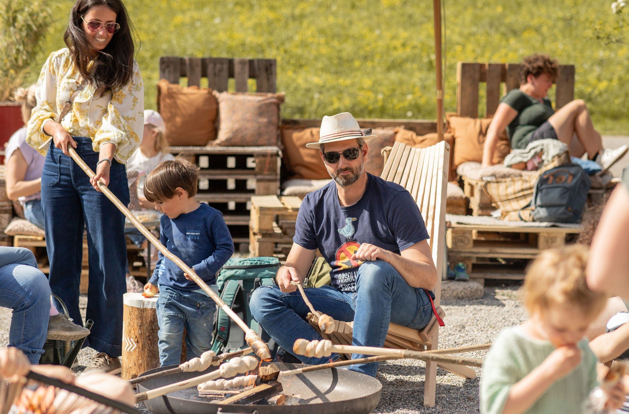 Familie sitzt um Grillstelle im Rahmen von Atzmännig Kultur im Sommer