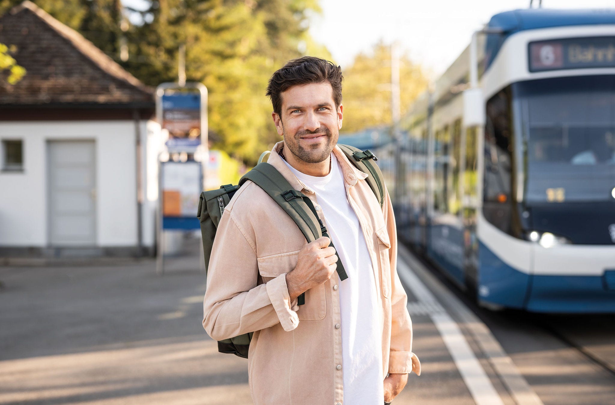 Mann vor Tram an Haltestelle Zoo