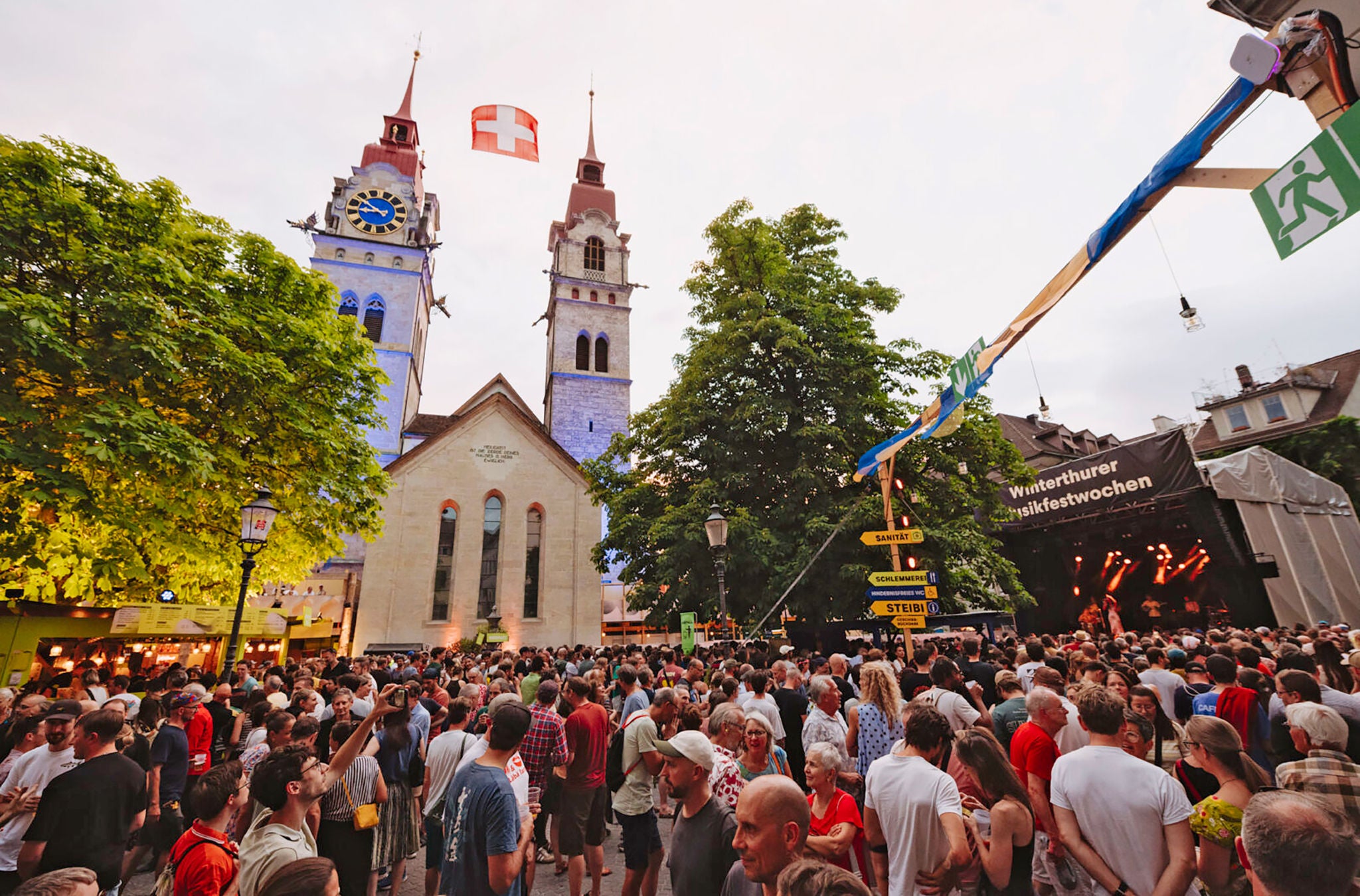 Menschen am Event vor einer Kirche. 