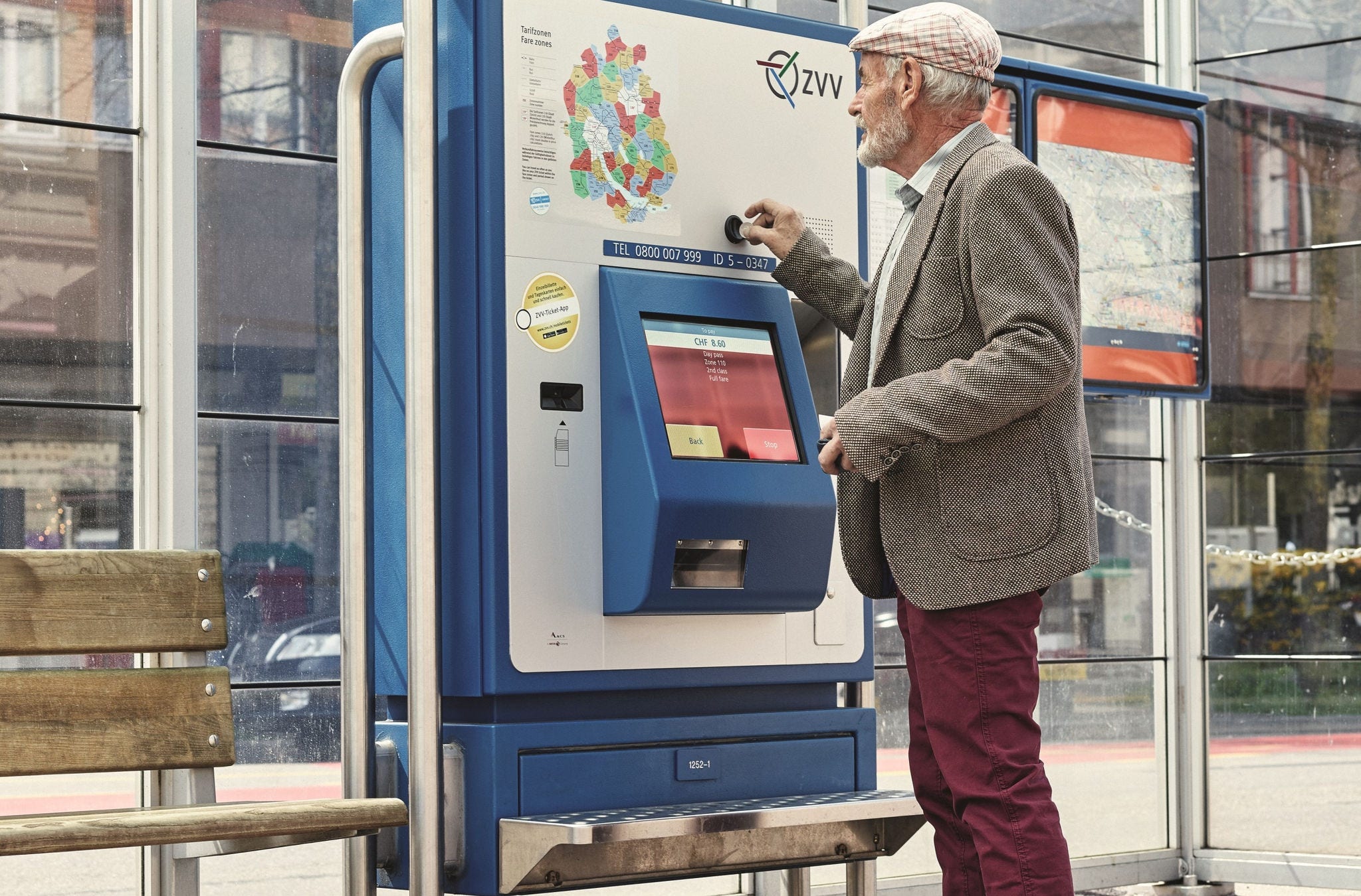 Ein Senior bedient den Ticketautomaten.
