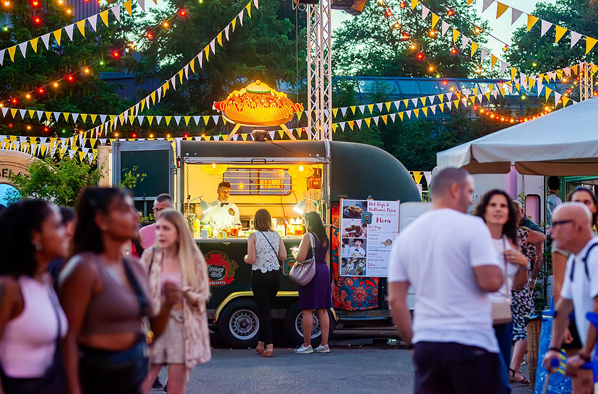 Foodtruck beleuchtet am Abend auf Street Food Fesetival Zürich mit Menschen