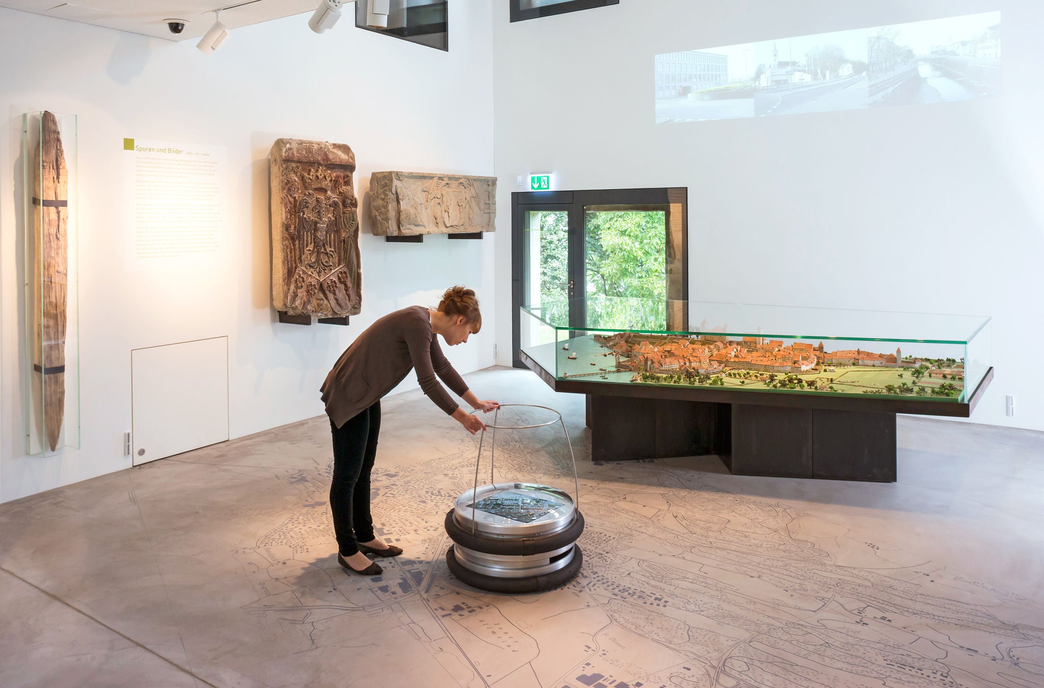 Frau im Museum sieht sich ein Ausstellungstück genau an.