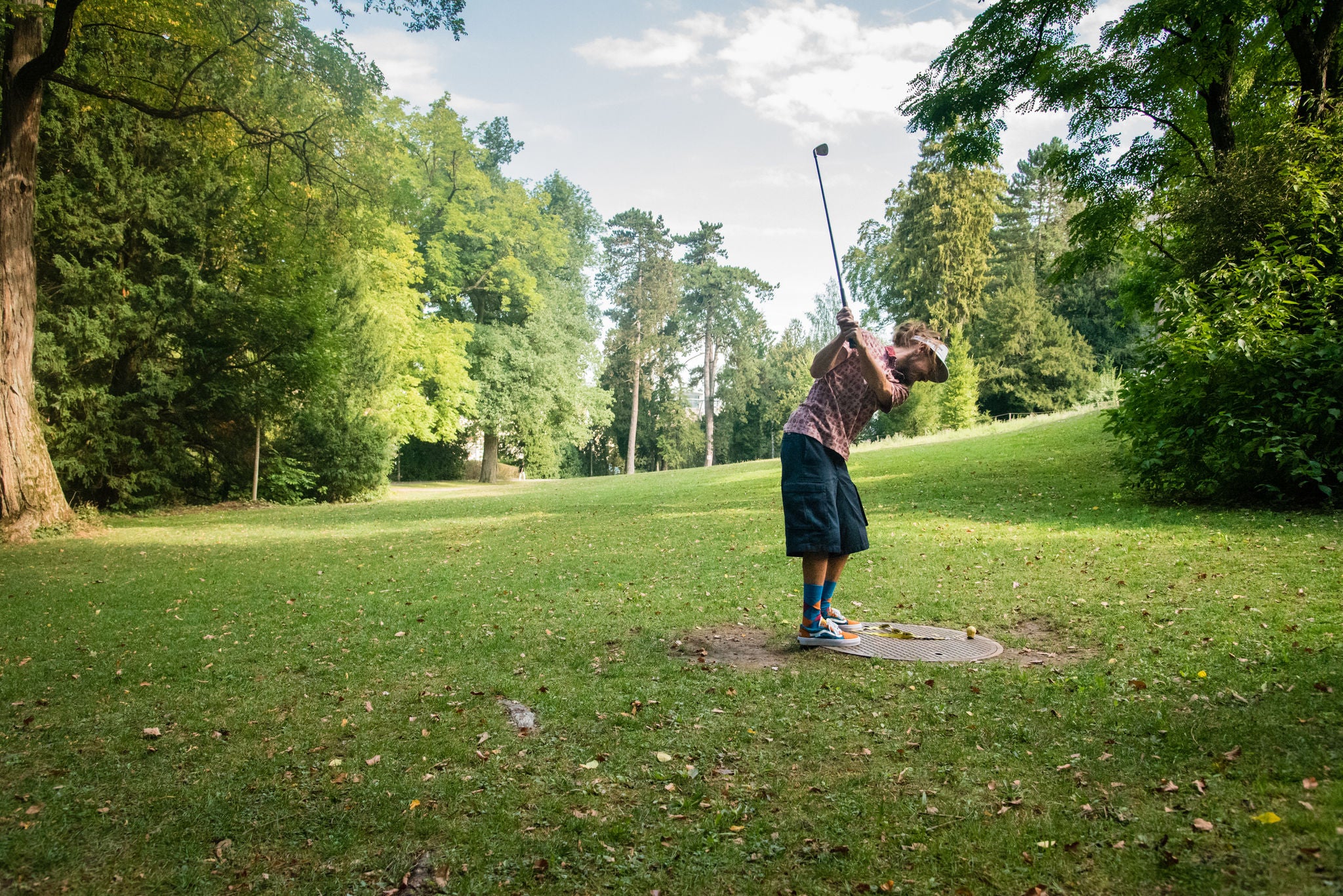 Ein Mann spielt Urban Golf in einem Park.