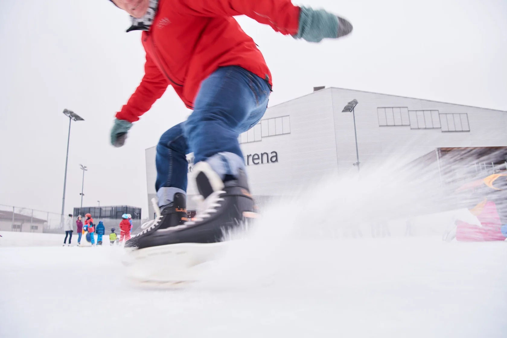 Ein Kind bremst auf Schlittschuhen.