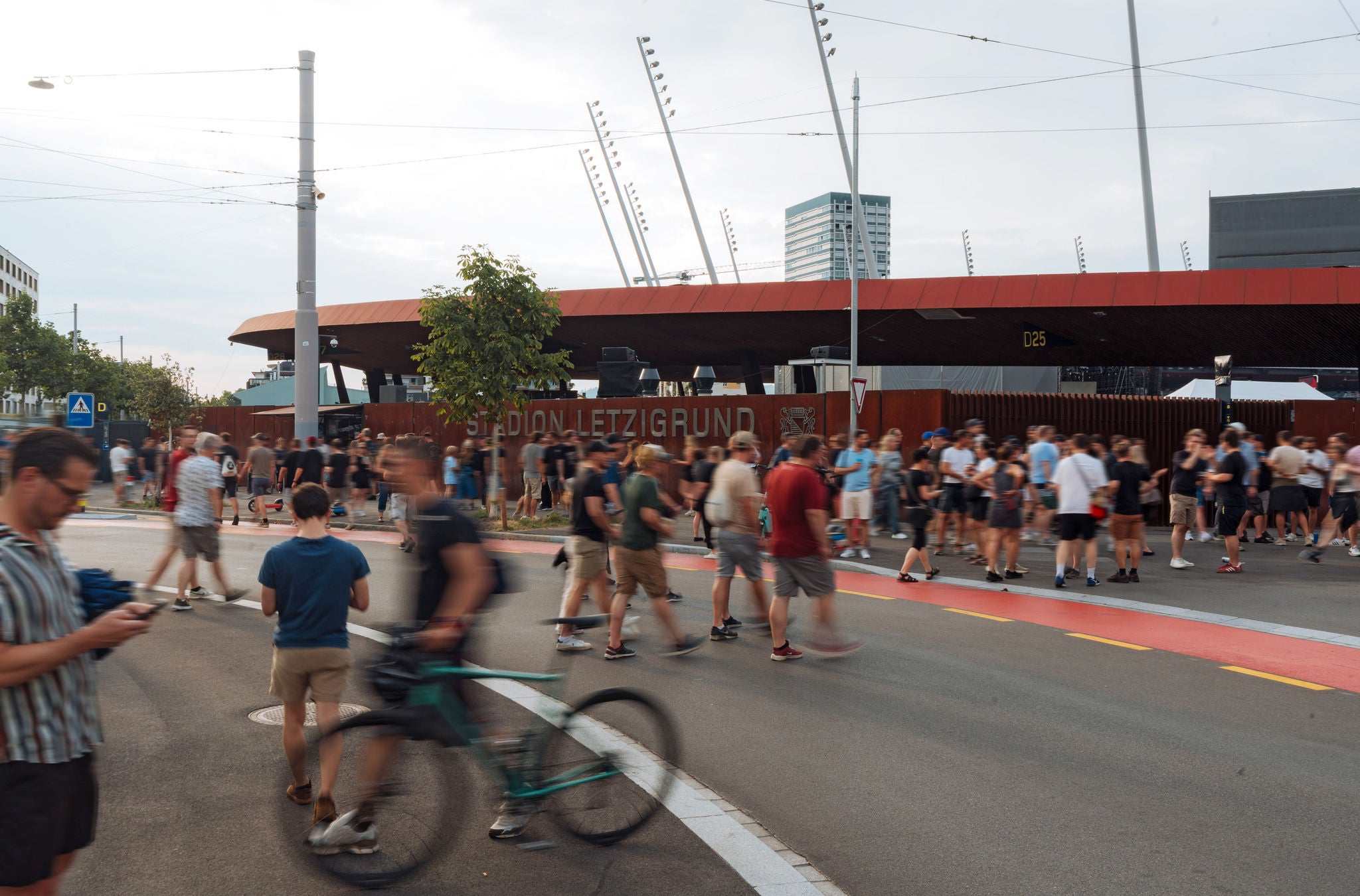Menschen an Konzert vor Stadion. 