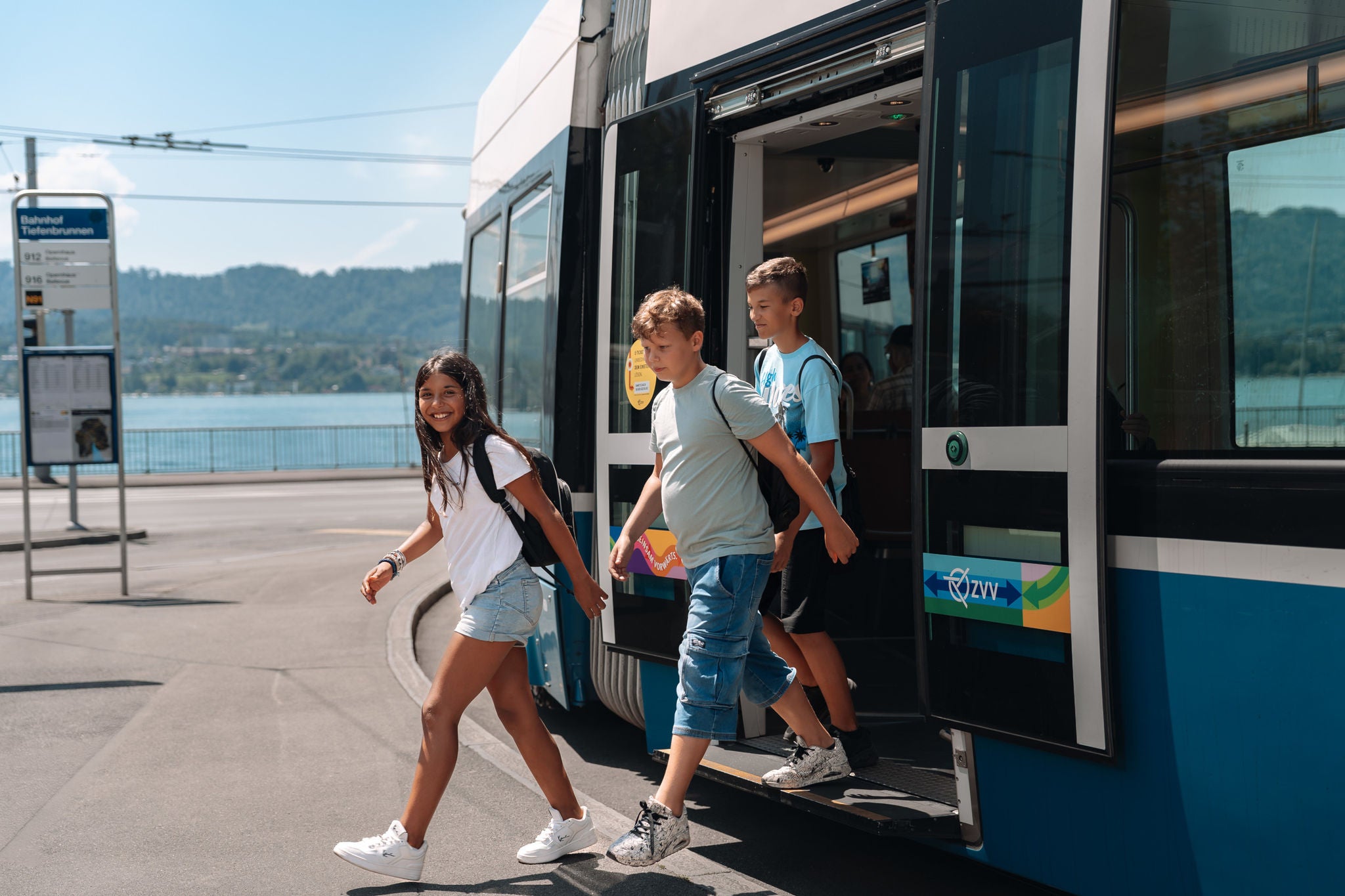 Kinder steigen auf einer Schulreise aus dem Tram am Bahnhof Tiefenbrunnen.