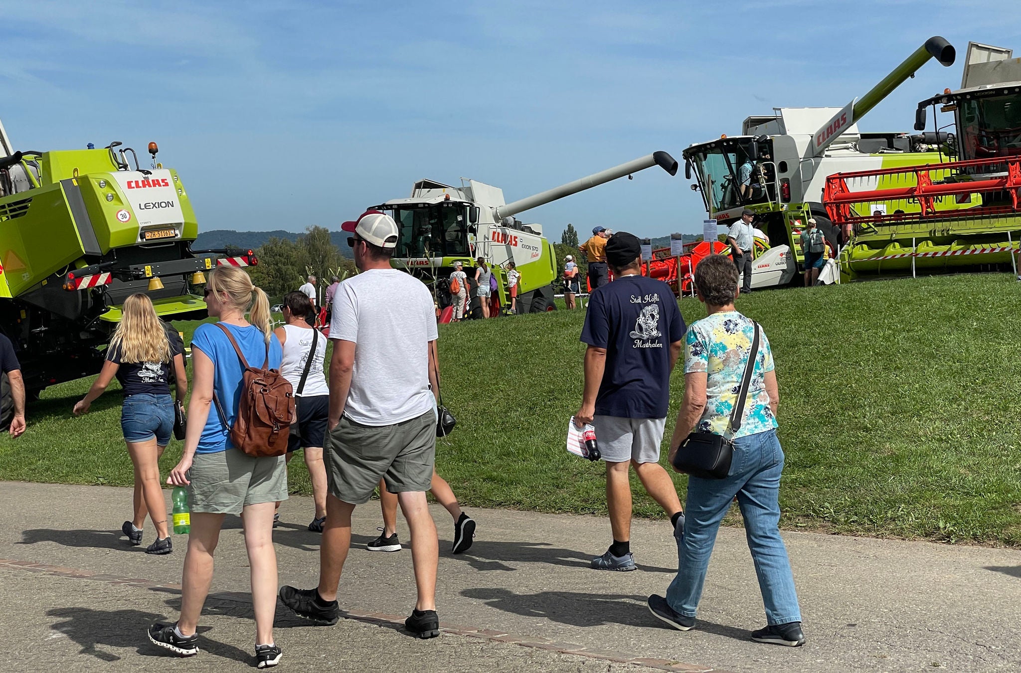 Mähdrescher auf Feld mit Menschen.
