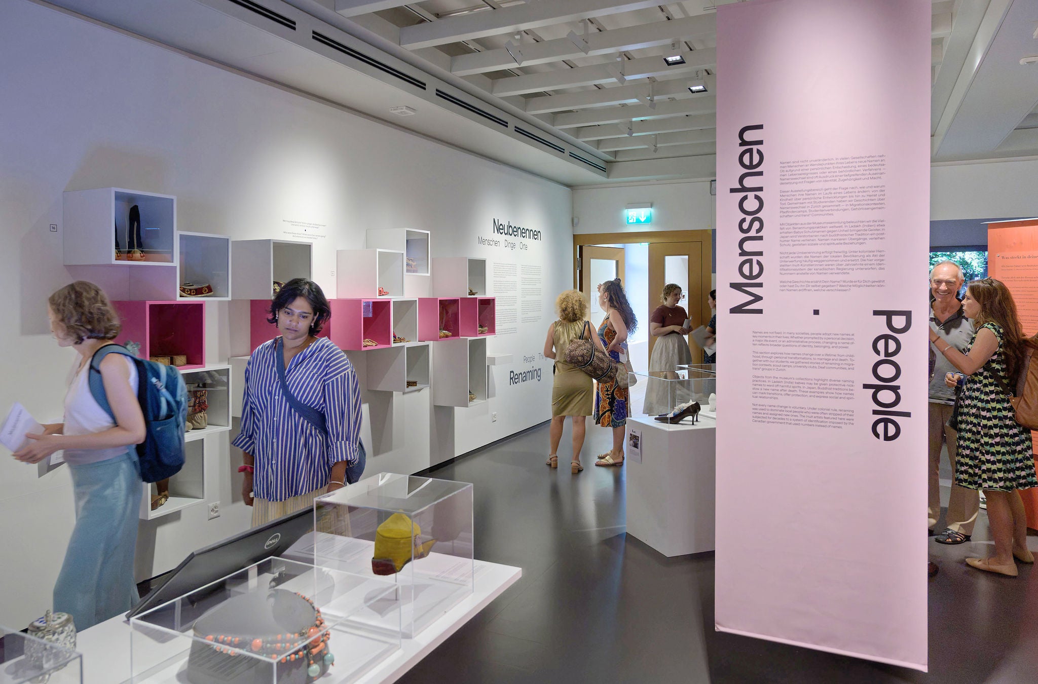 Ausstellungsraum im Völkerkundemuseum der Universität Zürich mit vielen Besuchenden. 