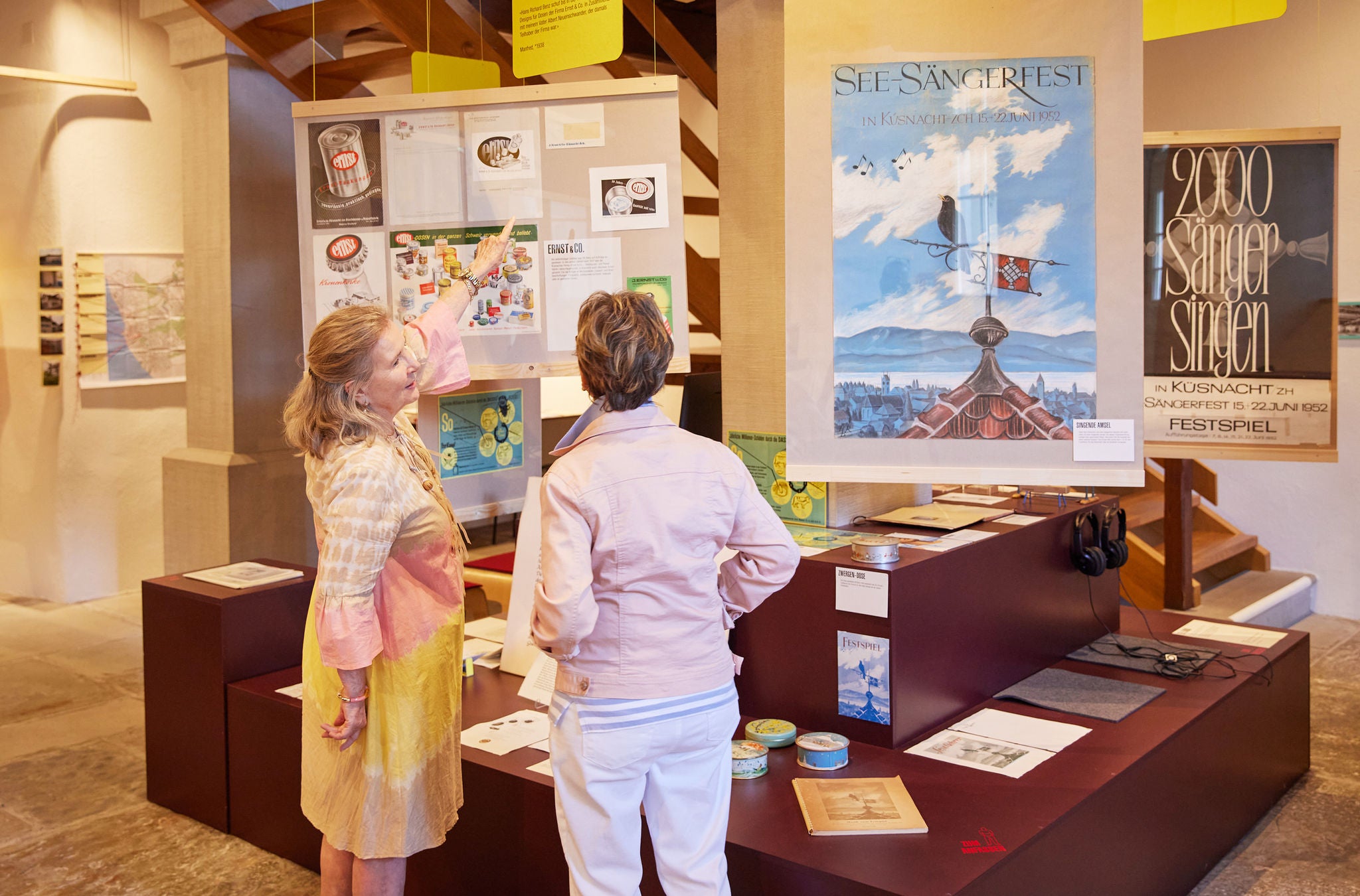 Zwei Personen stehen vor einem Ausstellungsplakat im Ortsmuseum Küsnacht.