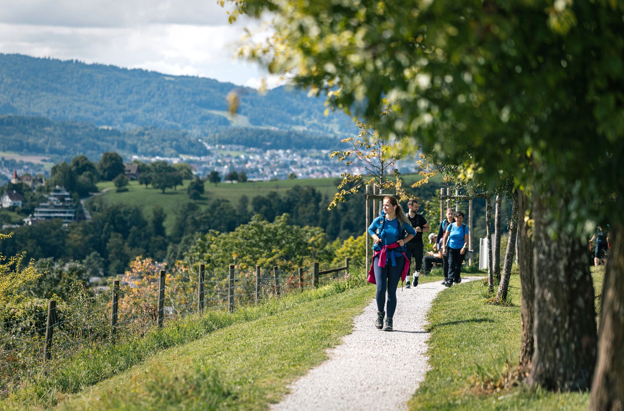 Personen gehen auf einem Wanderweg. 