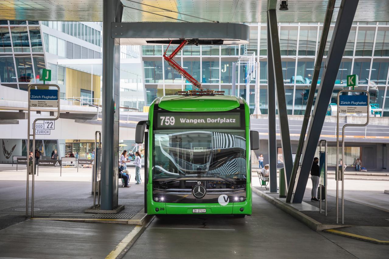 Ein grüner E-Bus der VBG lädt sich an der Ladestation am Flughafen auf.