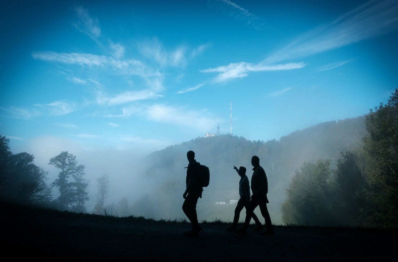 Eine Gruppe wandert mit Blick auf den Uetliberg.