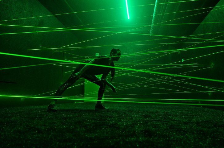 Frau läuft durch Laserstrahlen in der Adventure Arena Dübendorf