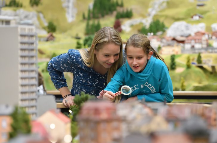 Mutter und Tochter mit Lupe in der Miniaturwelt «Smilestones» am Rheinfall