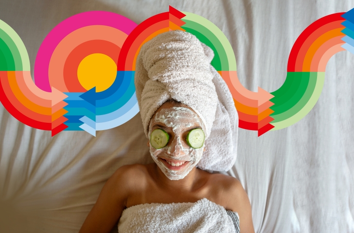 Frau mit Gurkenscheiben auf den Augen, Badetuch um den Kopf gewickelt und Gesichtsmaske am wellnessen.