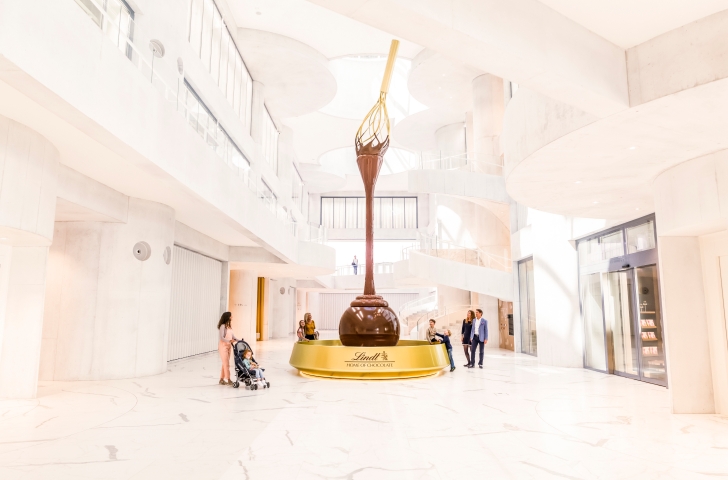 Besucherinnen und Besucher bestaunen den Schokoladenbrunnen im Lindt Home of Chocolate
