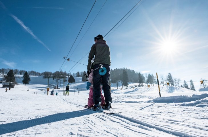 Mann mit Kind auf Tellerlift am Atzmännig Goldingen im Winter