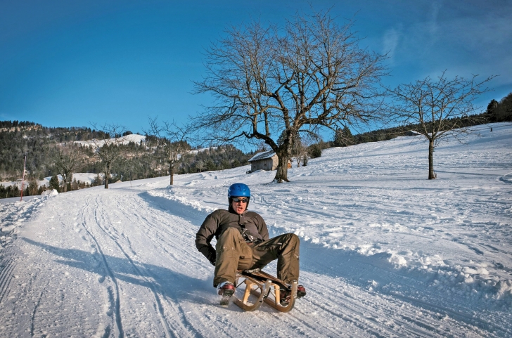 Mann auf der Schlittelpiste am Atzmännig Goldingen im Winter