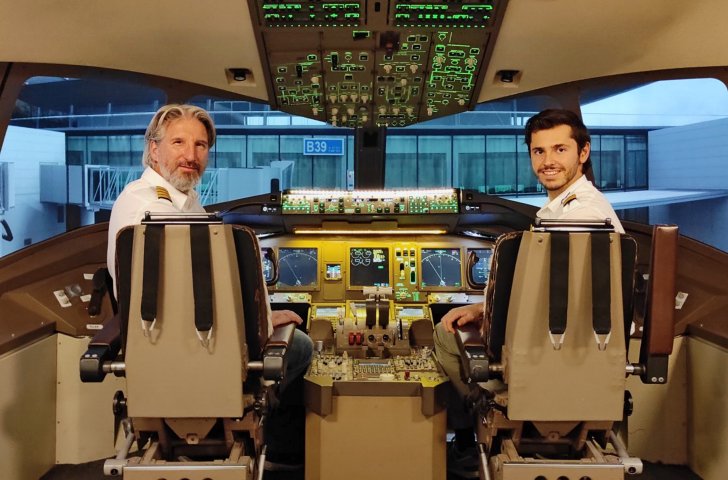 Zwei Mitarbeiter sitzen im Cockpit einer Flugsimulation von Fly and Race Simulations Zürich.