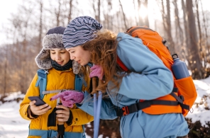 Mutter und Kind schauen in ein Smartphone und entdecken die ZVV-Freizeit-App.