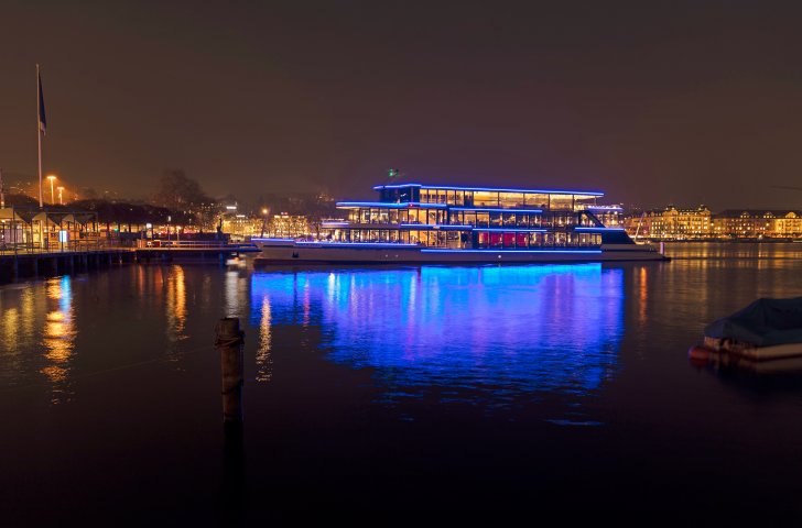 Beleuchtetes Schiff auf dem Zürichsee an einem Winterabend