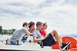 Vier Jugendliche sitzen im Pedalo auf dem Zürichsee.