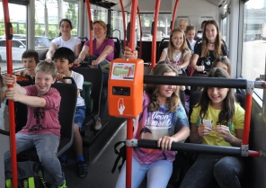 Ein Chauffeur instruiert eine Gruppe Schulkinder vor dem ZVV-Schulbus.