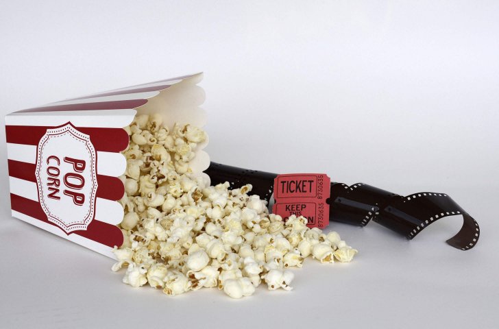 Eine umgekippte Popcorn-Tüte vor einem Filmstreifen
